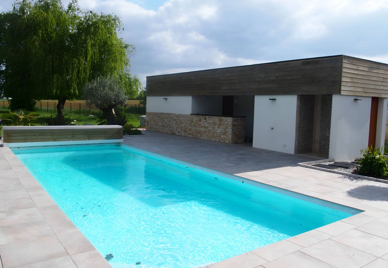 Vue aérienne d'une magnifique piscine creusée en extérieur entourée d'un paysage enchanteur