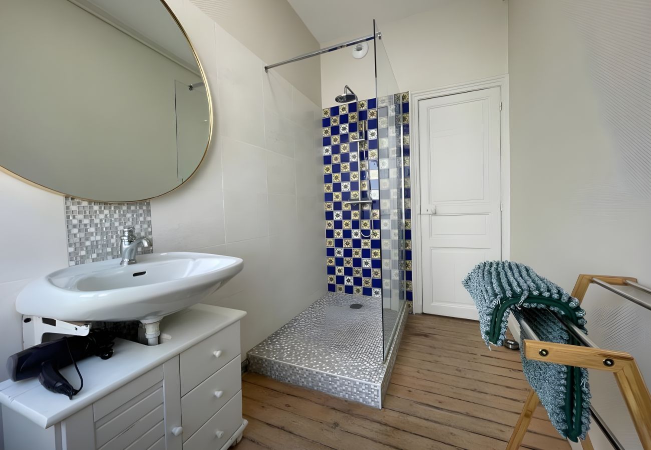 Salle d'eau Au Soleil Levant : douche à l'italienne, lavabo, meubles, porte-serviettes, miroir, parquet.