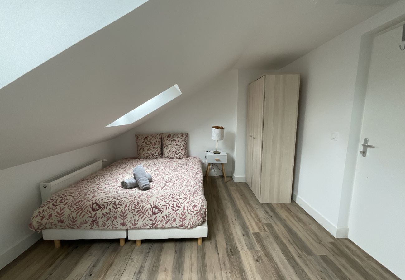 Chambre avec lit double, armoire et table de chevet au Family, offrant un espace de repos chic et pratique.