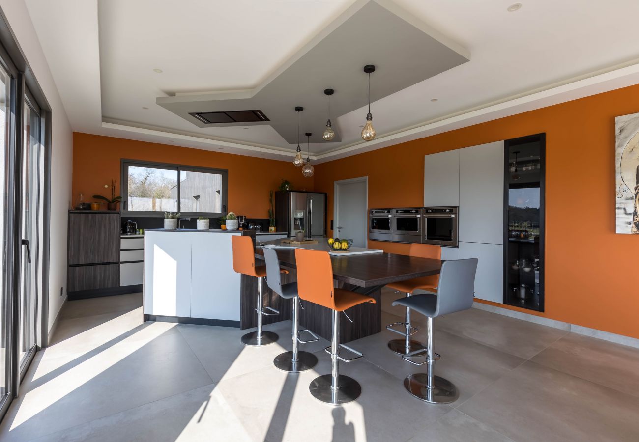 Cuisine moderne avec îlot central et vue dégagée depuis l'intérieur