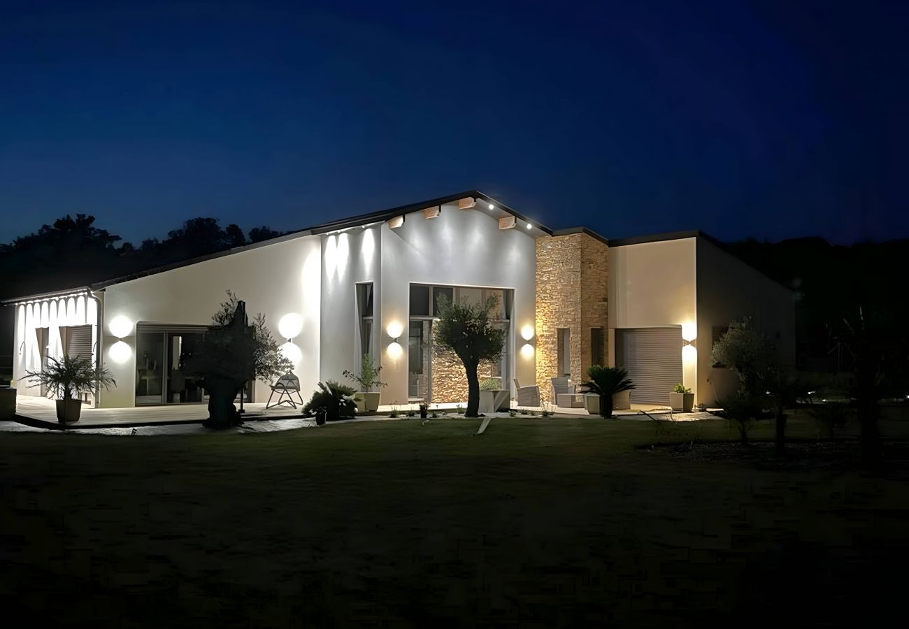 Vue nocturne de la façade illuminée de la Maison Le Dina Robin