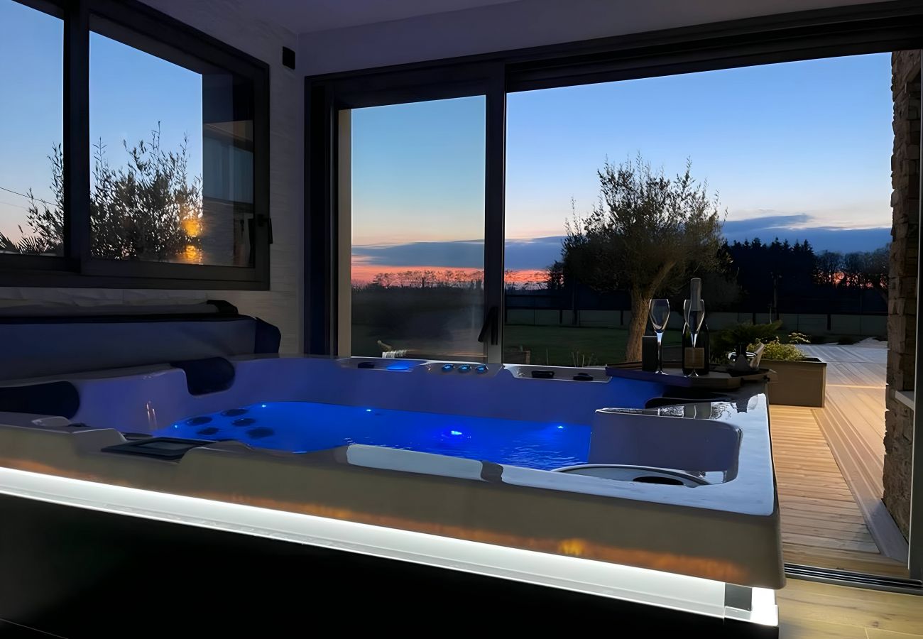 Espace bain/spa avec vue sur le coucher de soleil et la terrasse, offrant une expérience de détente ultime