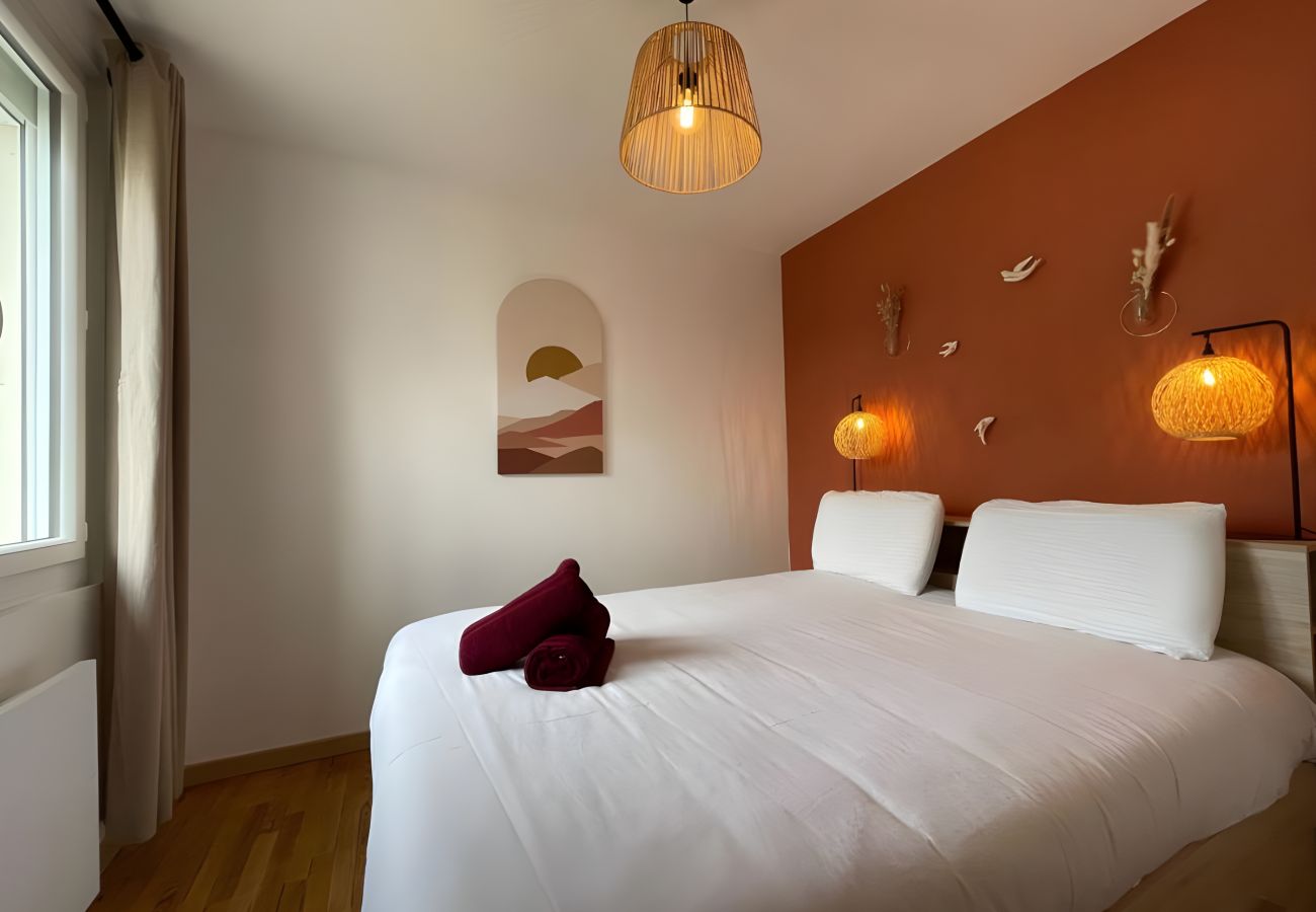 Chambre confortable à L'Enchantement. Literie de qualité, éclairage chaleureux, ambiance apaisante et décoration élégante.