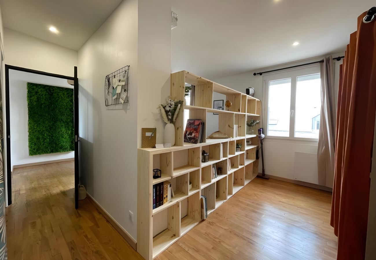 Étagère cube en bois moderne séparant le salon en deux espaces distincts.